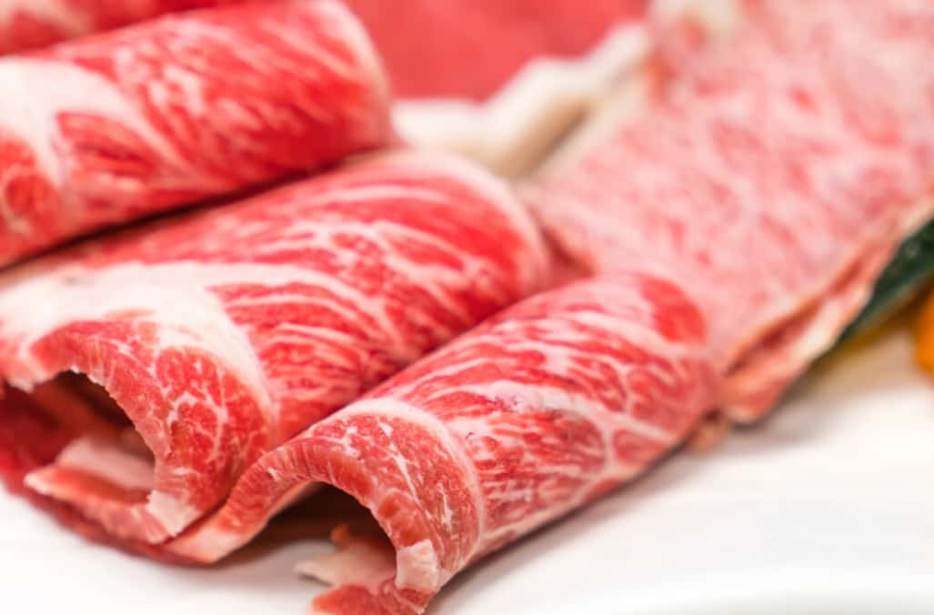 Rolled slices of marbled beef arranged on a dish