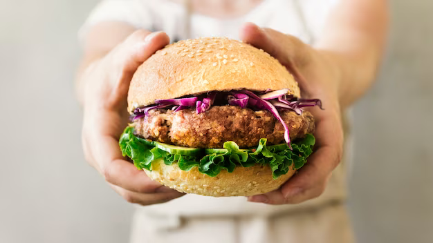 Close-up of a chef holding a burger in his hands